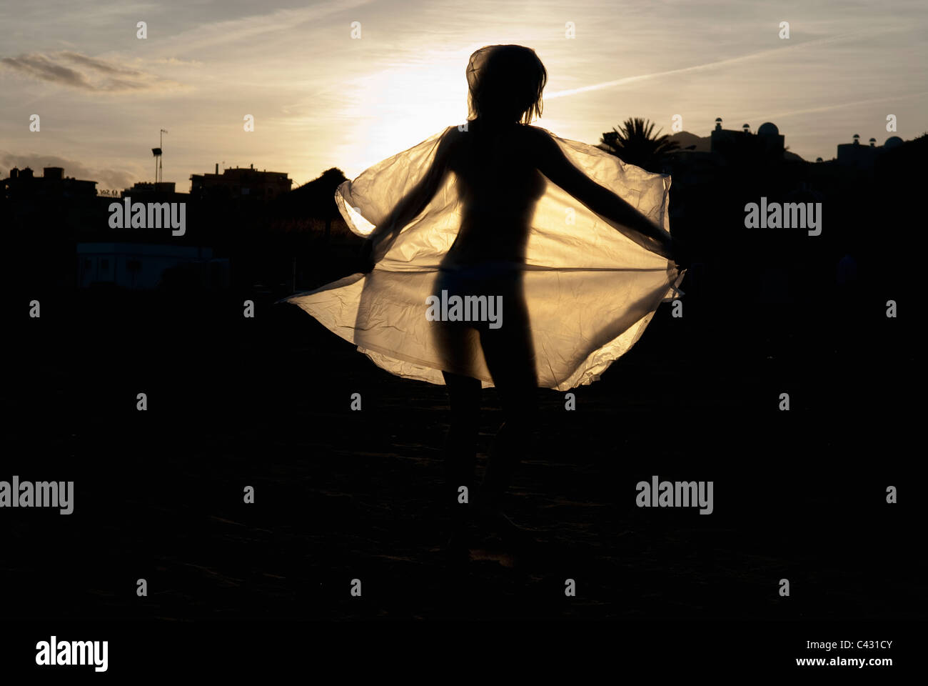 dancing woman silhouetted against the setting sun Stock Photo
