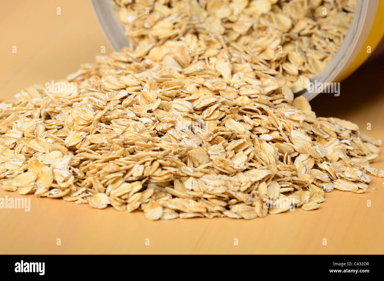 Oatmeal spilling out of bin. Selective focus on middle of pile. Stock Photo