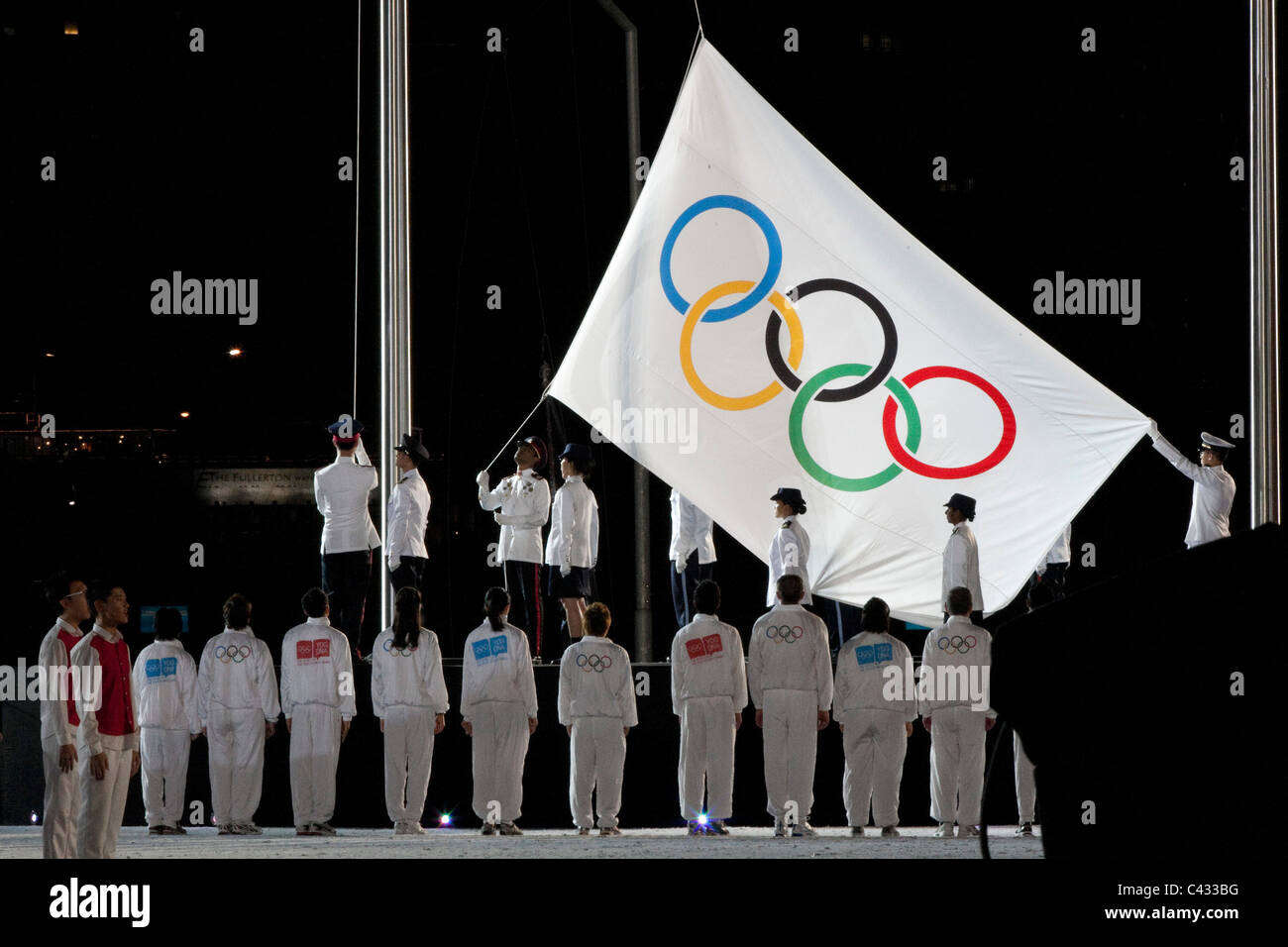 The Olympic flag is raised during the 2010 Singapore Youth Olympic Games Opening Ceremony. Stock Photo