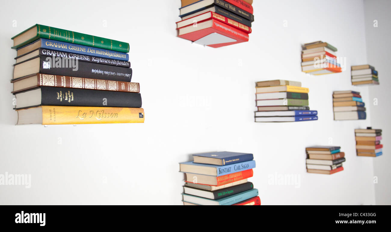 Stacks of books hanging on a wall Stock Photo Alamy
