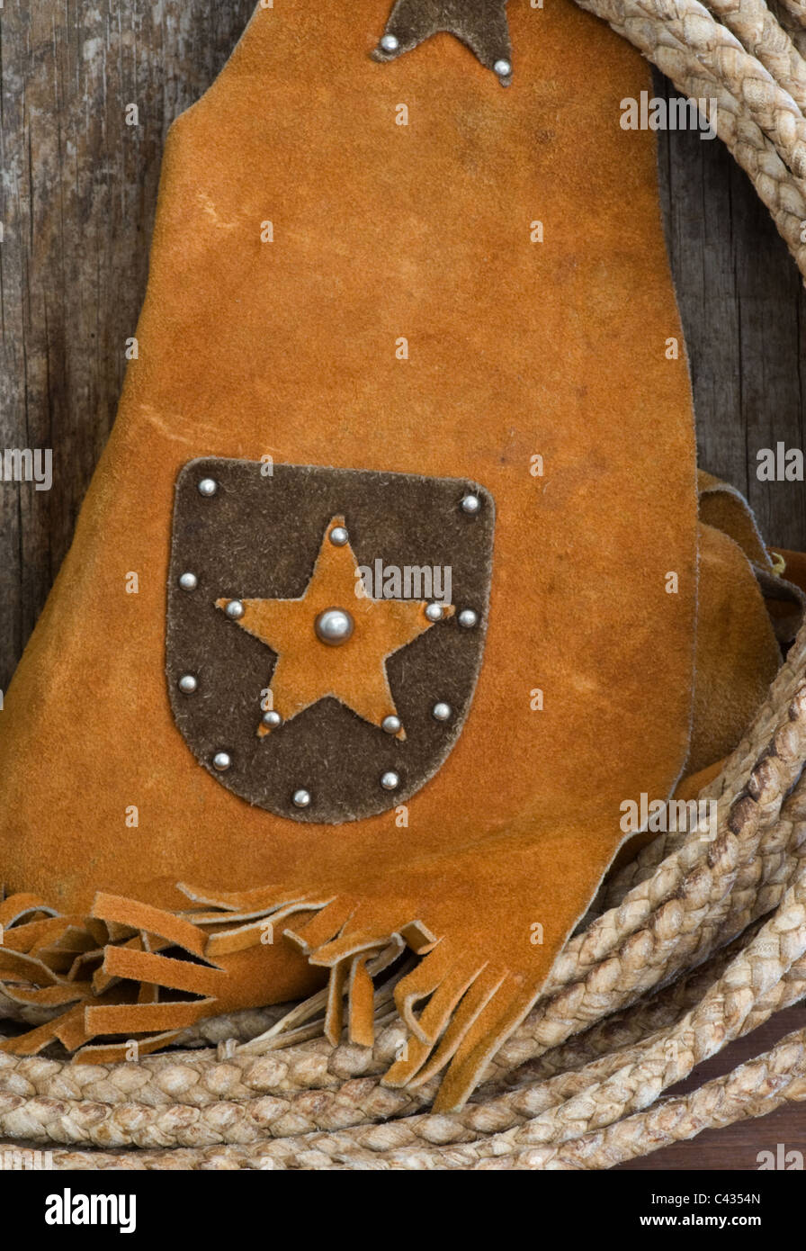 Closeup of western cowboy theme rawhide rope with leather star vest. Stock Photo