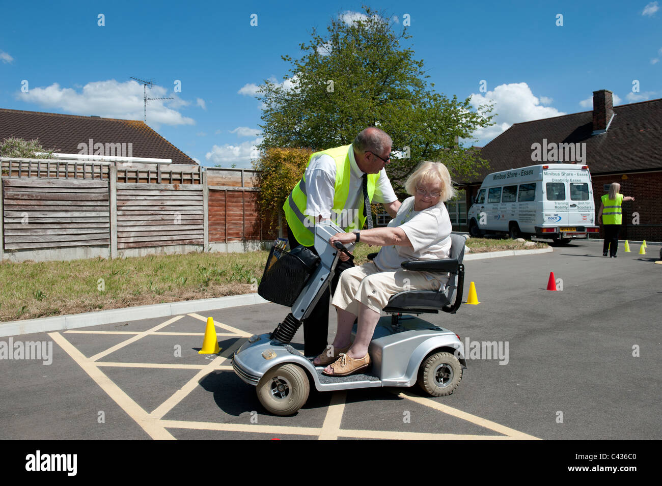 An elderly (senior) lady learning to ride a mobility scooter at the Centre for Disability Studies in Rochford, Essex. Stock Photo