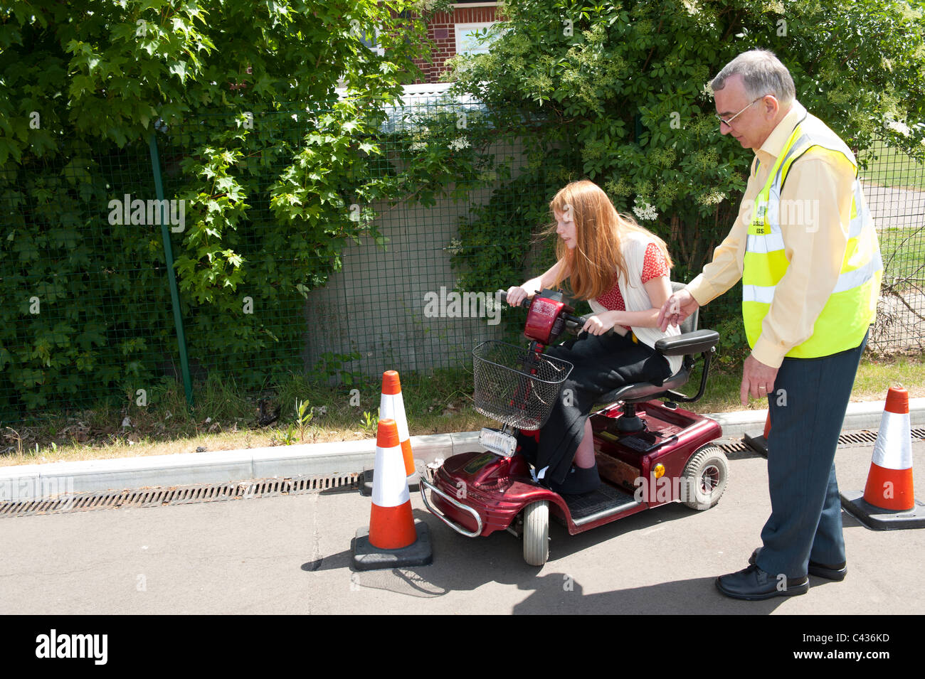 A young disabled girl undergoes instruction in the safe use of a mobility scooter at the Centre for Disability Studies in the UK Stock Photo