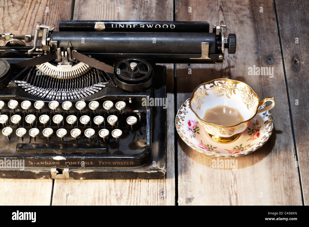 Vintage Underwood 3-bank portable typewriter and  vintage tea cup & saucer Stock Photo