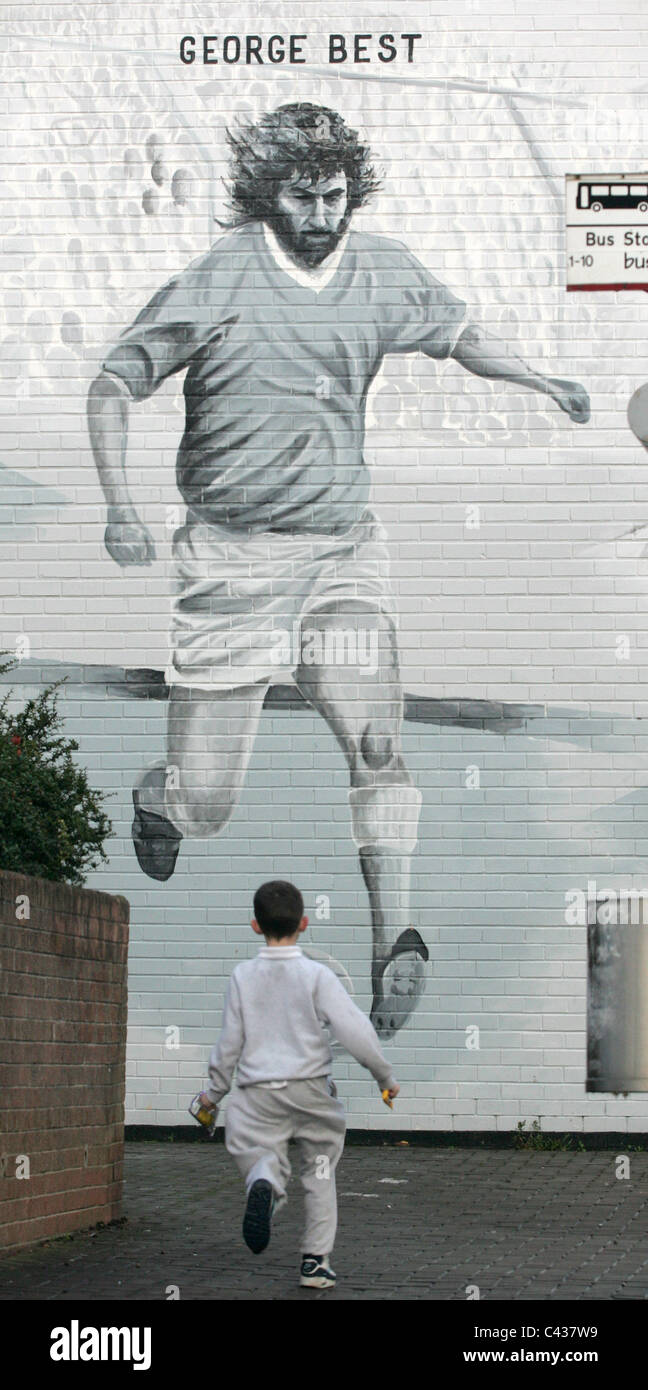 A young boy runs towards the Football legend Best mural in east