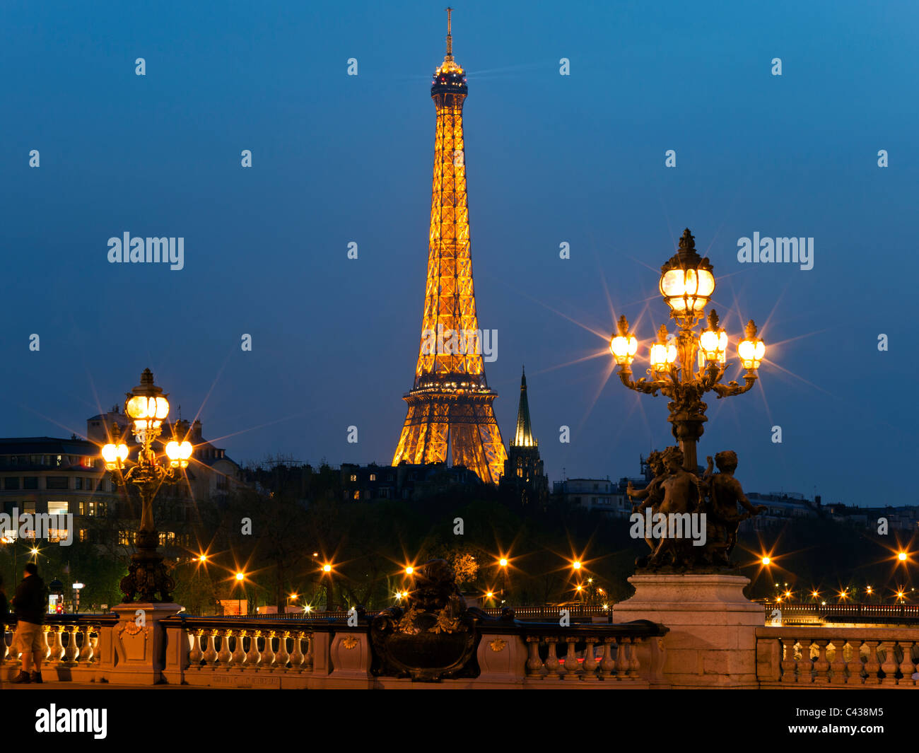 Night illumination on the bridge of Alexander III and Eiffel Tower in the background. Paris. France. Stock Photo