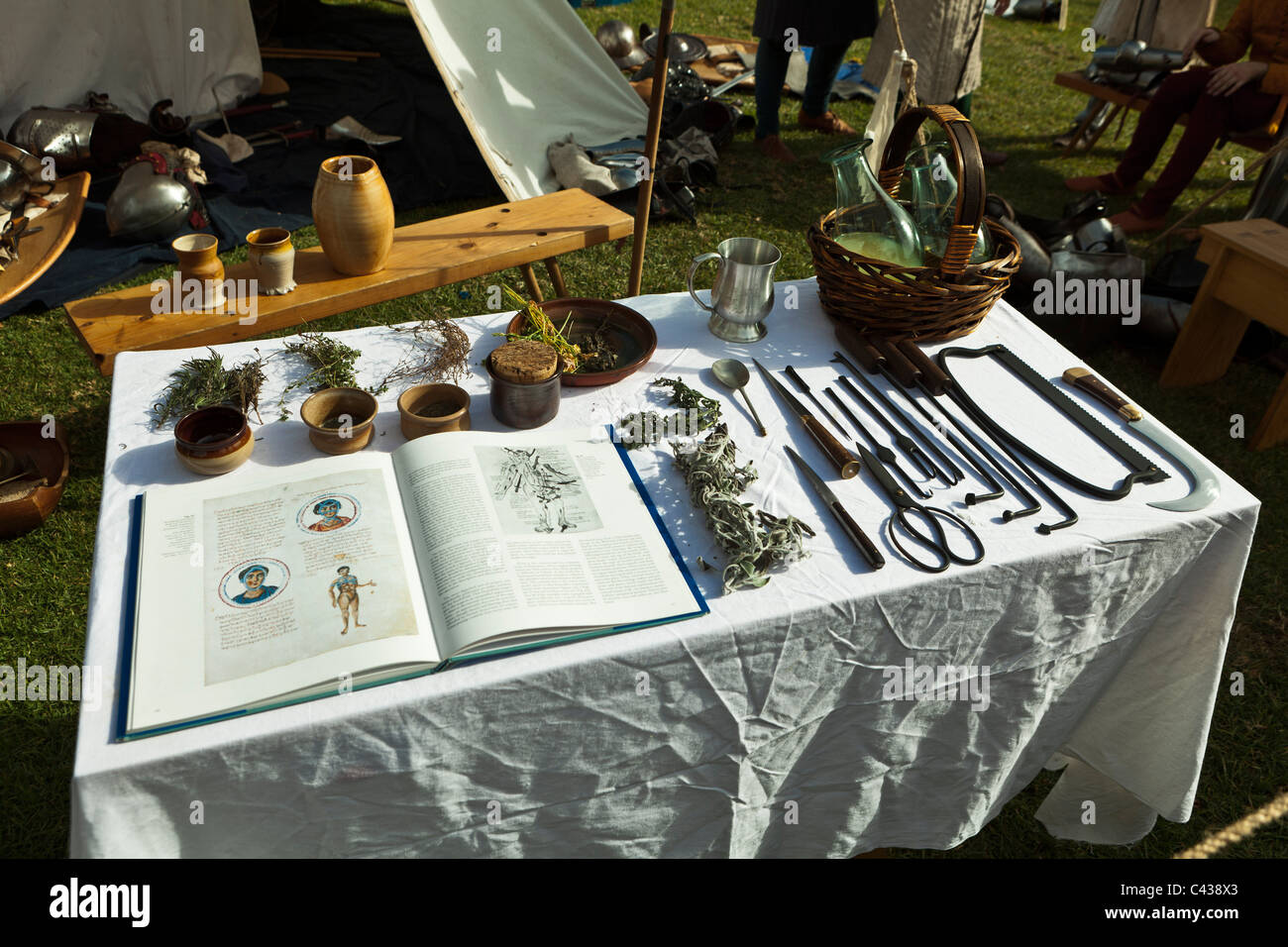 Old surgical instruments and a medical book on display at a medieval fair. Stock Photo