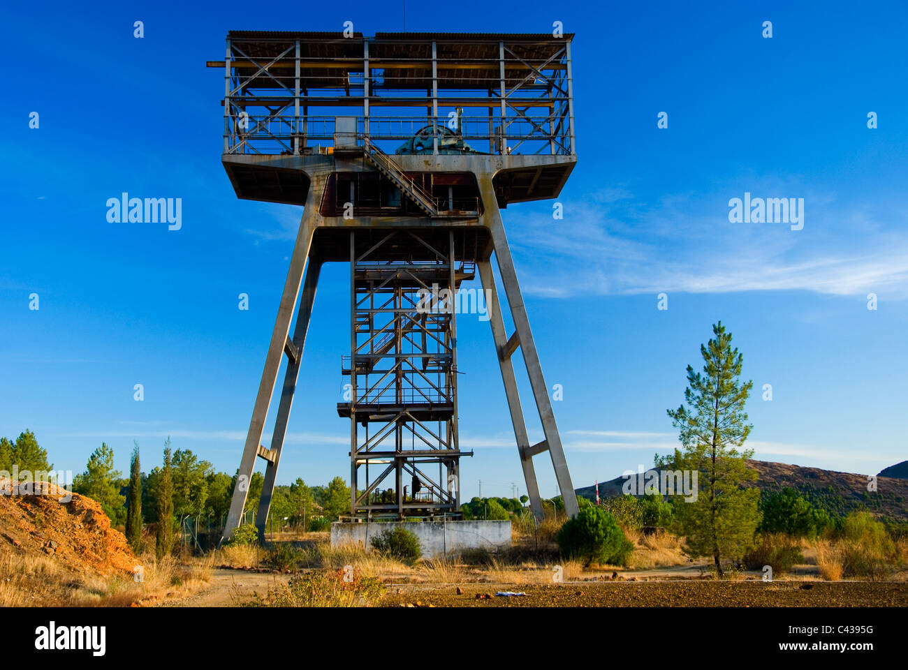 Abandoned big old mining shaft tower on blue background, part of the Route of Industrial Culture Riotinto Nerva, Huelva, Spain Stock Photo