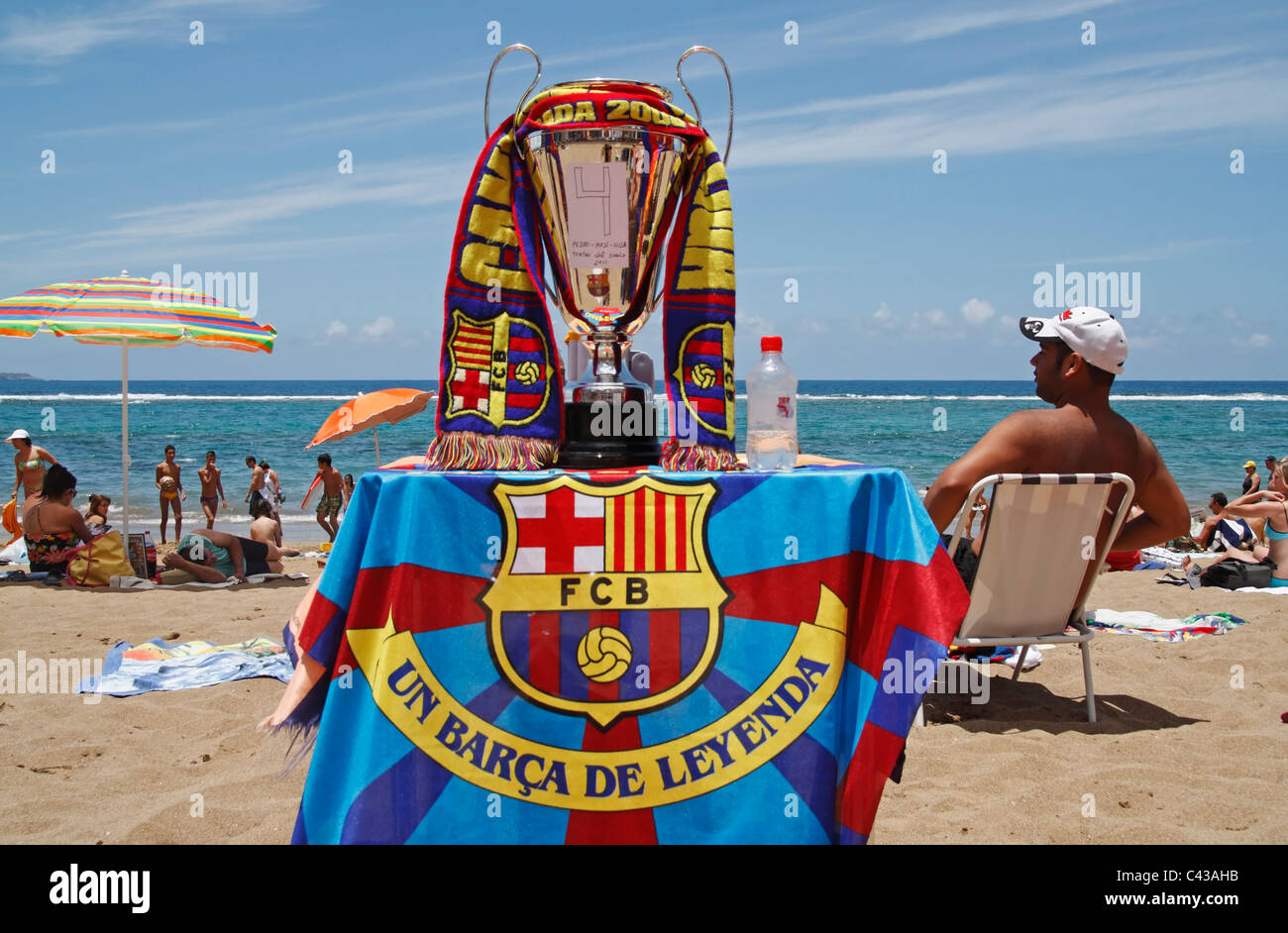 Barcelona supporters with replica Champions League cup on beach in Las