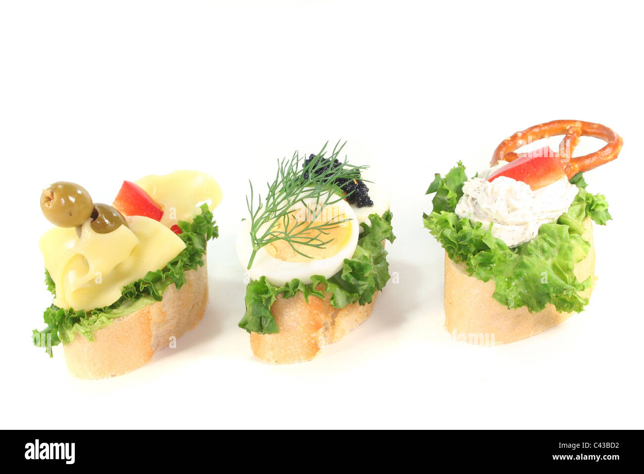 Canape with lettuce, cheese, sausage, cream cheese and eggs on a white background Stock Photo