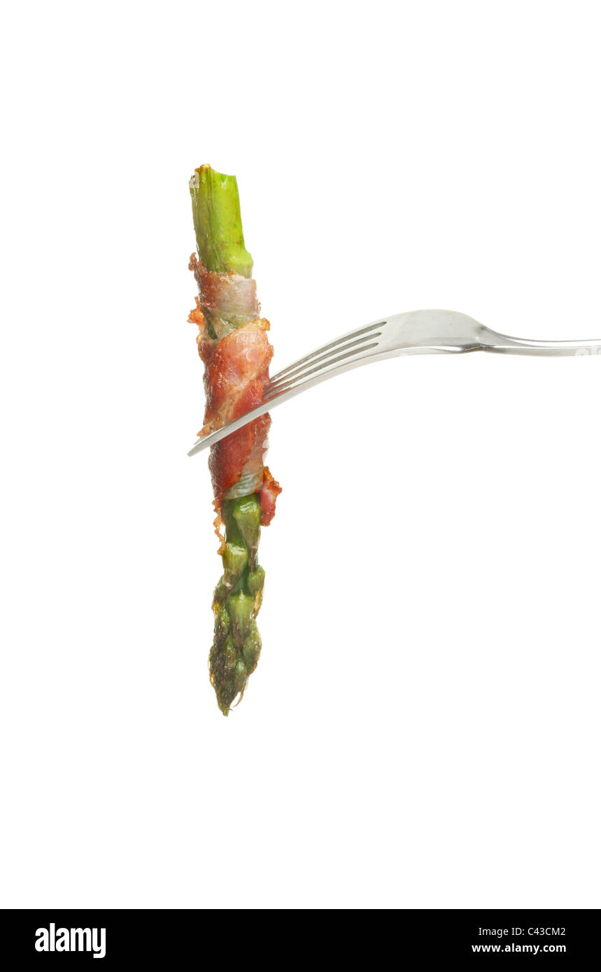 Asparagus spear cooked with pancetta ham on a fork isolated against white Stock Photo