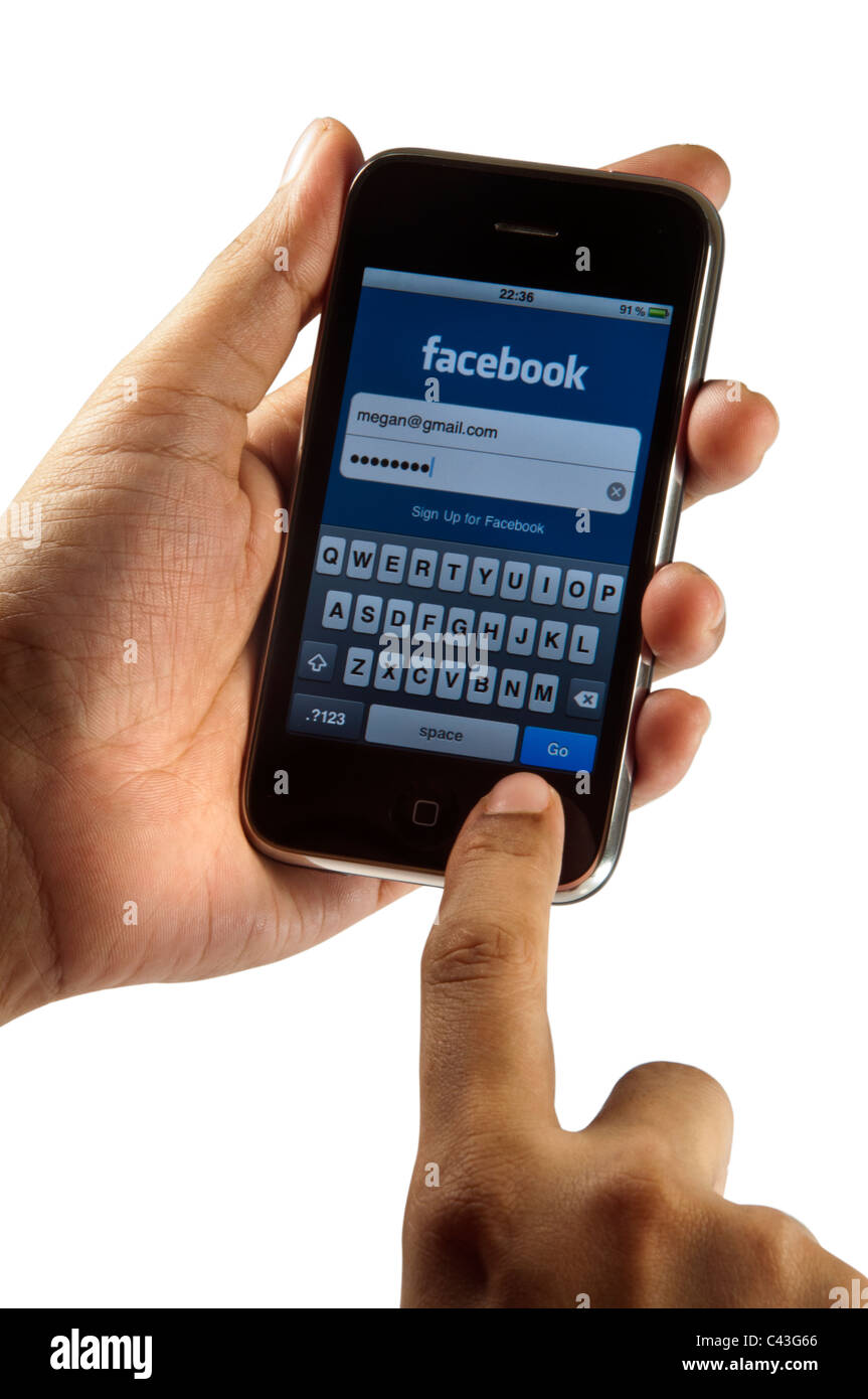 Hand holding Iphone login facebook account Stock Photo