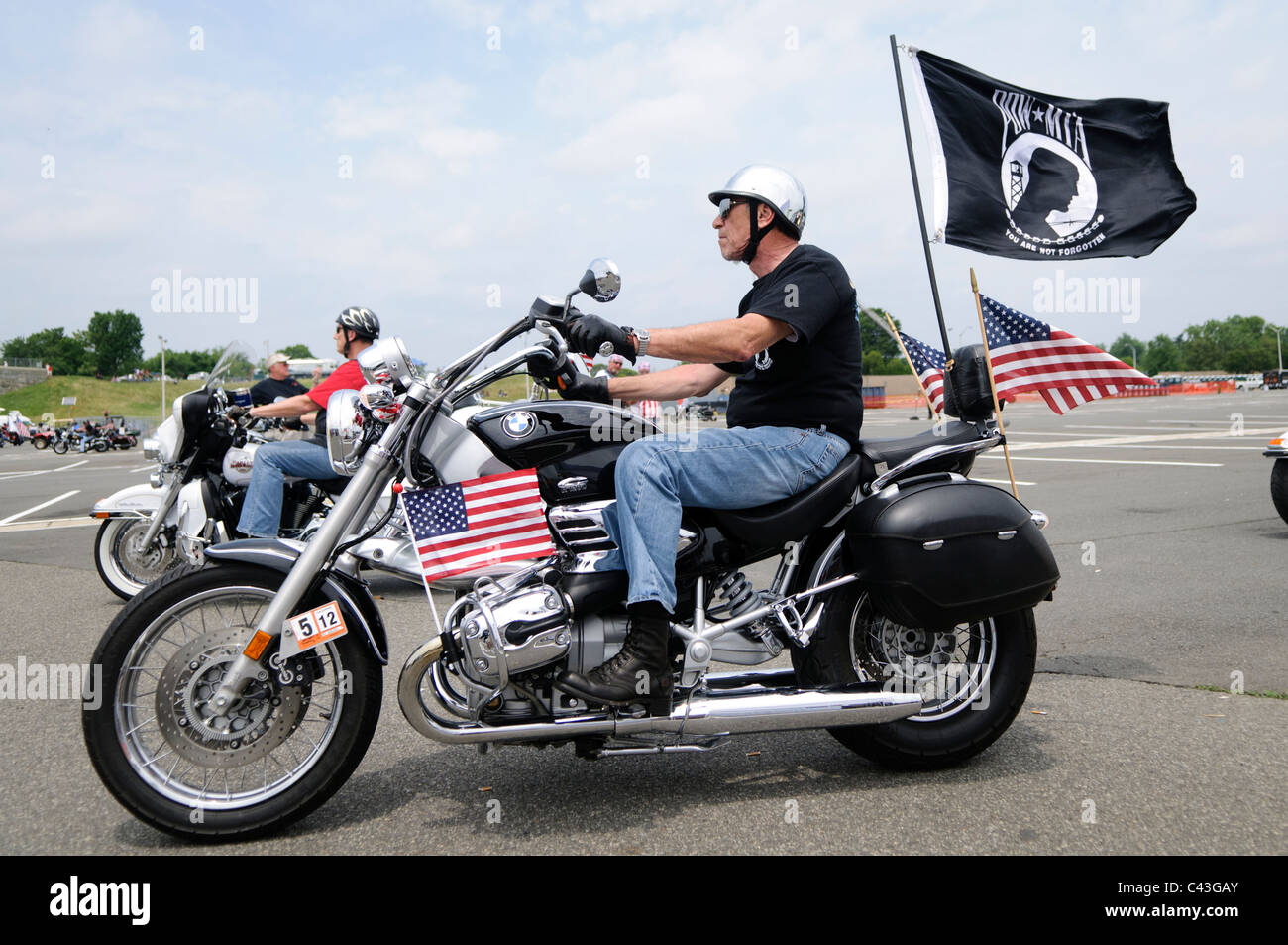 ARLINGTON, VA - A rider with a POW-MIA (Prisoner of War - Missing in Action) flag participating in the annual Rolling Thunder motorcycle rally through downtown Washington DC on May 29, 2011. This shot was taken as the riders were leaving the staging area in the Pentagon's north parking lot, where thousands of bikes and riders had gathered. Stock Photo