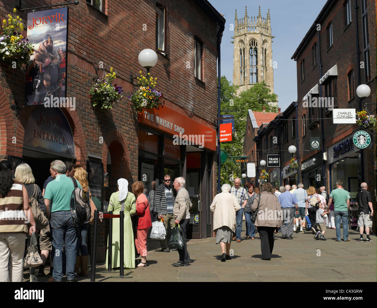 People queuing outside the Jorvik Viking Centre Coppergate and All Saints Church in the background York North Yorkshire England UK United Kingdom GB Stock Photo