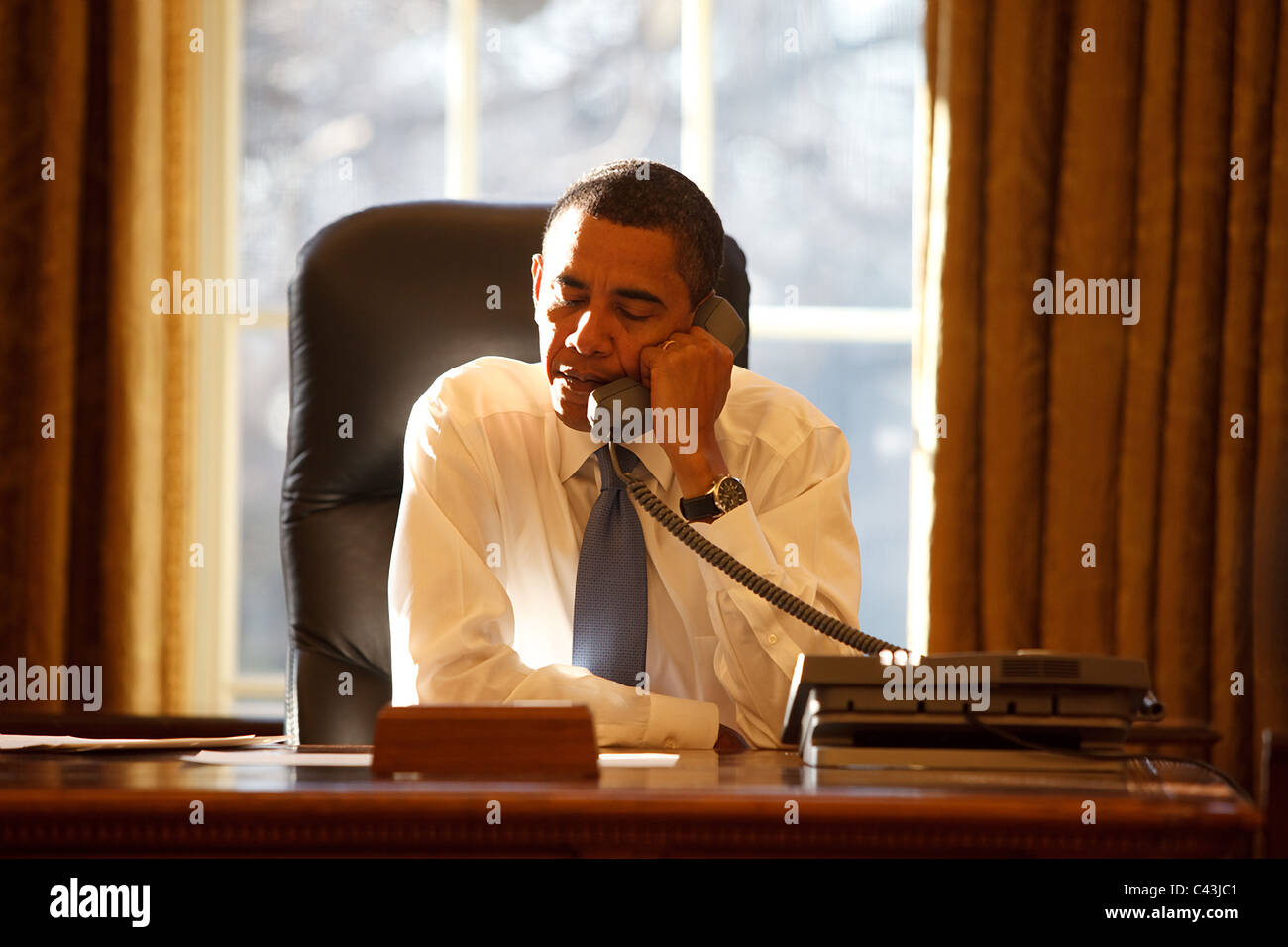 President Barack Obama speaks with a foreign leader in the Oval Office on his first day in office Stock Photo