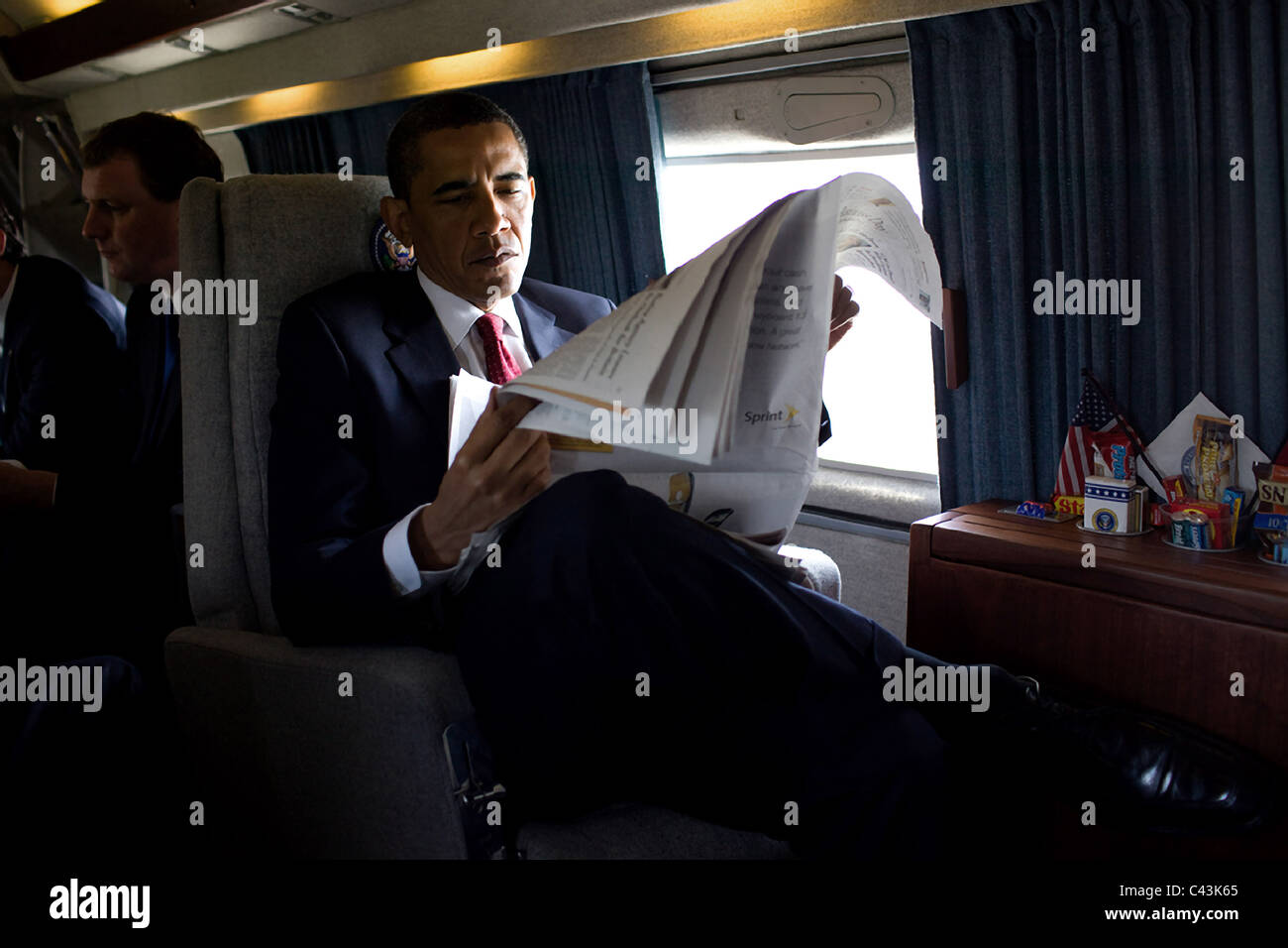 President Barack Obama reads a morning newspaper aboard Marine One while en route to the US Naval Academy Stock Photo