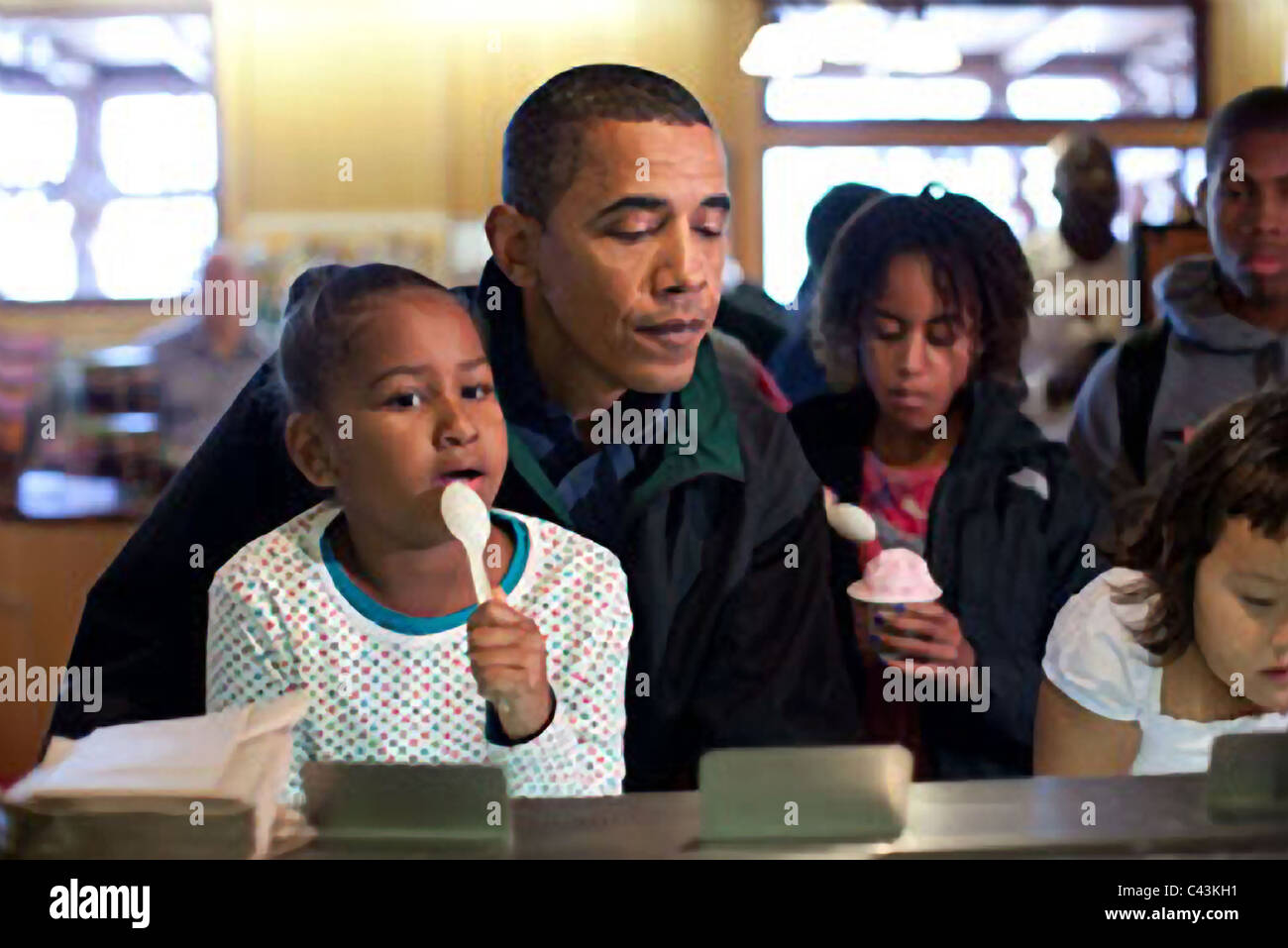 President Barack Obama and daughter Sasha look over the different flavors of ice cream available at a store Stock Photo