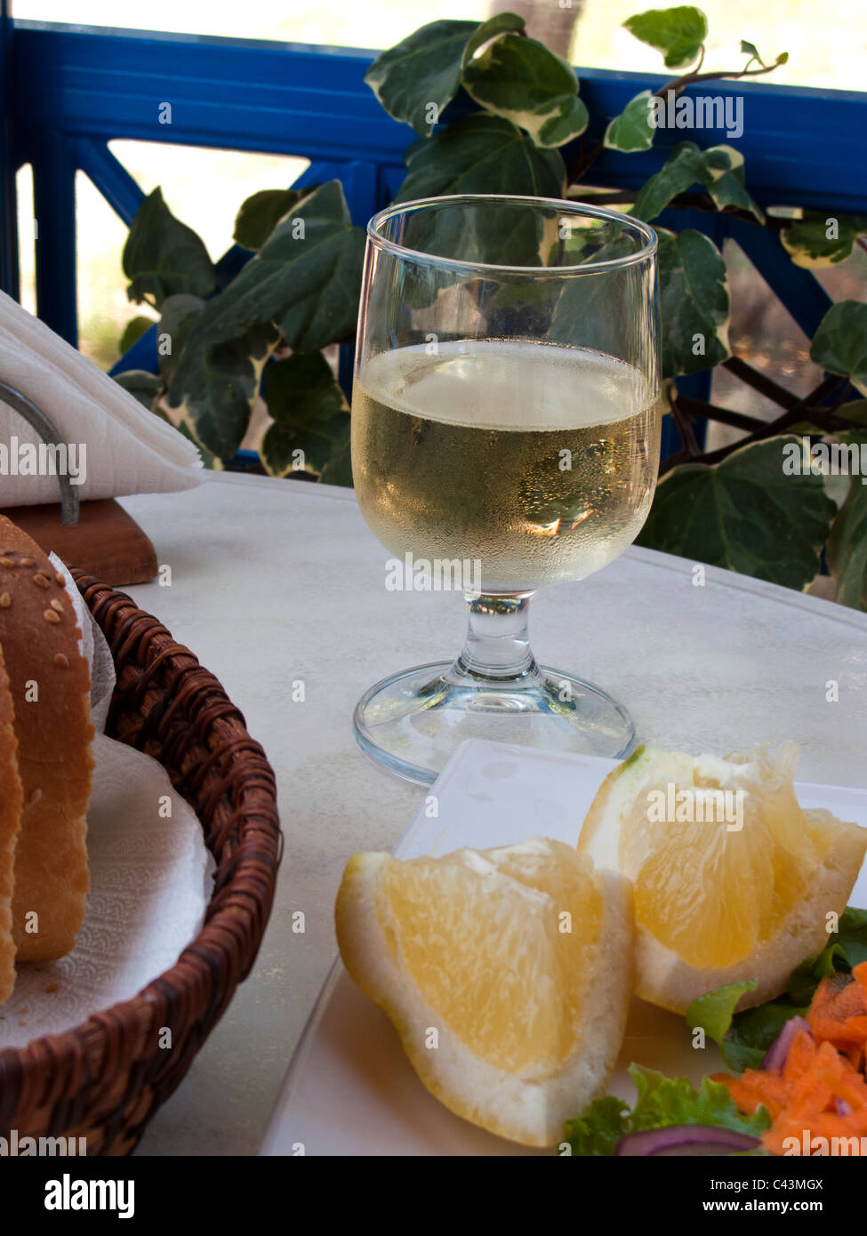 SELECTIVE FOCUS IMAGE OF A WHITE WINE GLASS IN A RESTAURANT OUTDOORS IN GREECE Stock Photo