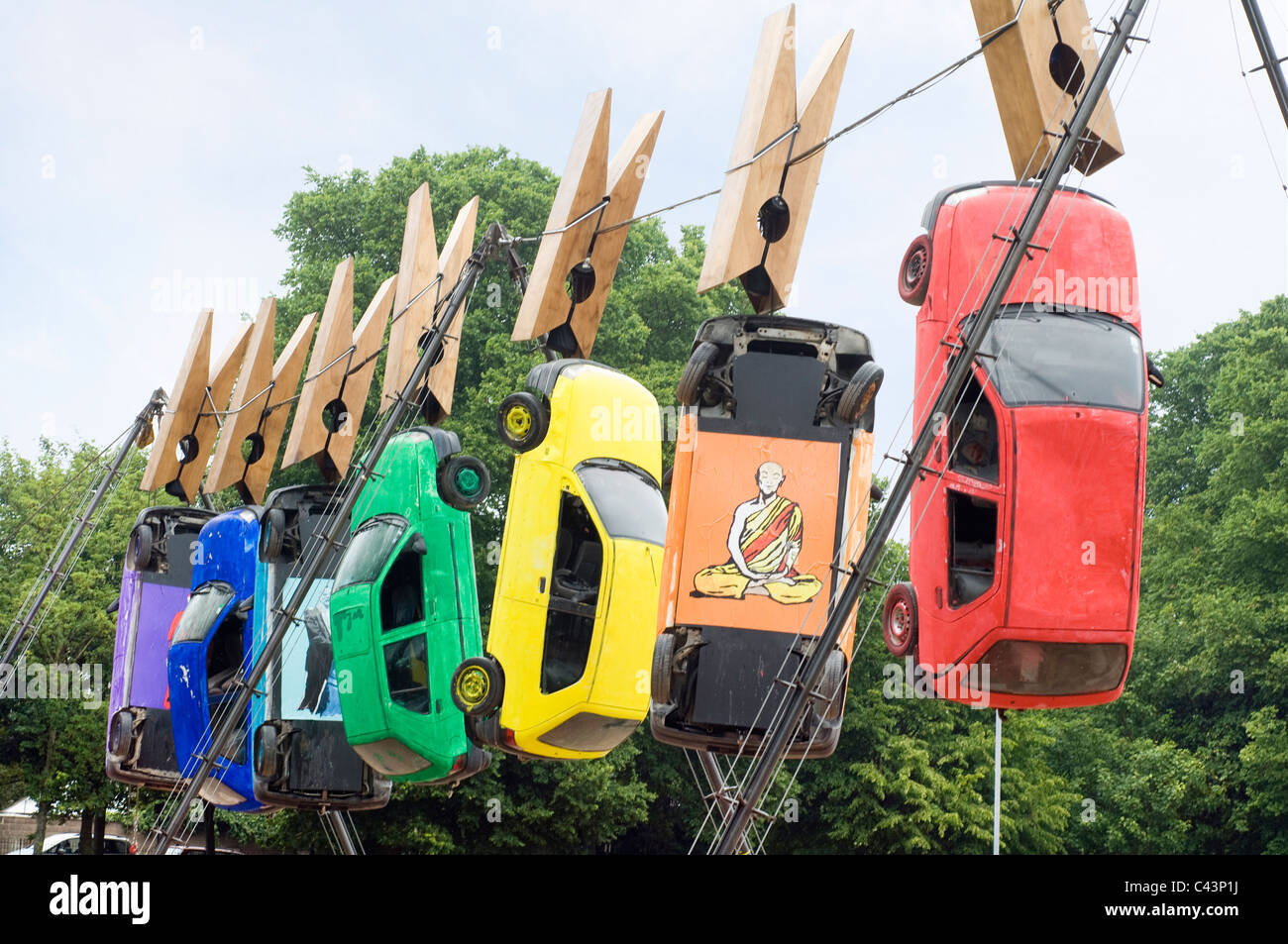 Seven cars hang from giant clothes pegs on a wire in Brighton as part of the annual Art Festival Fringe street theatre. Stock Photo