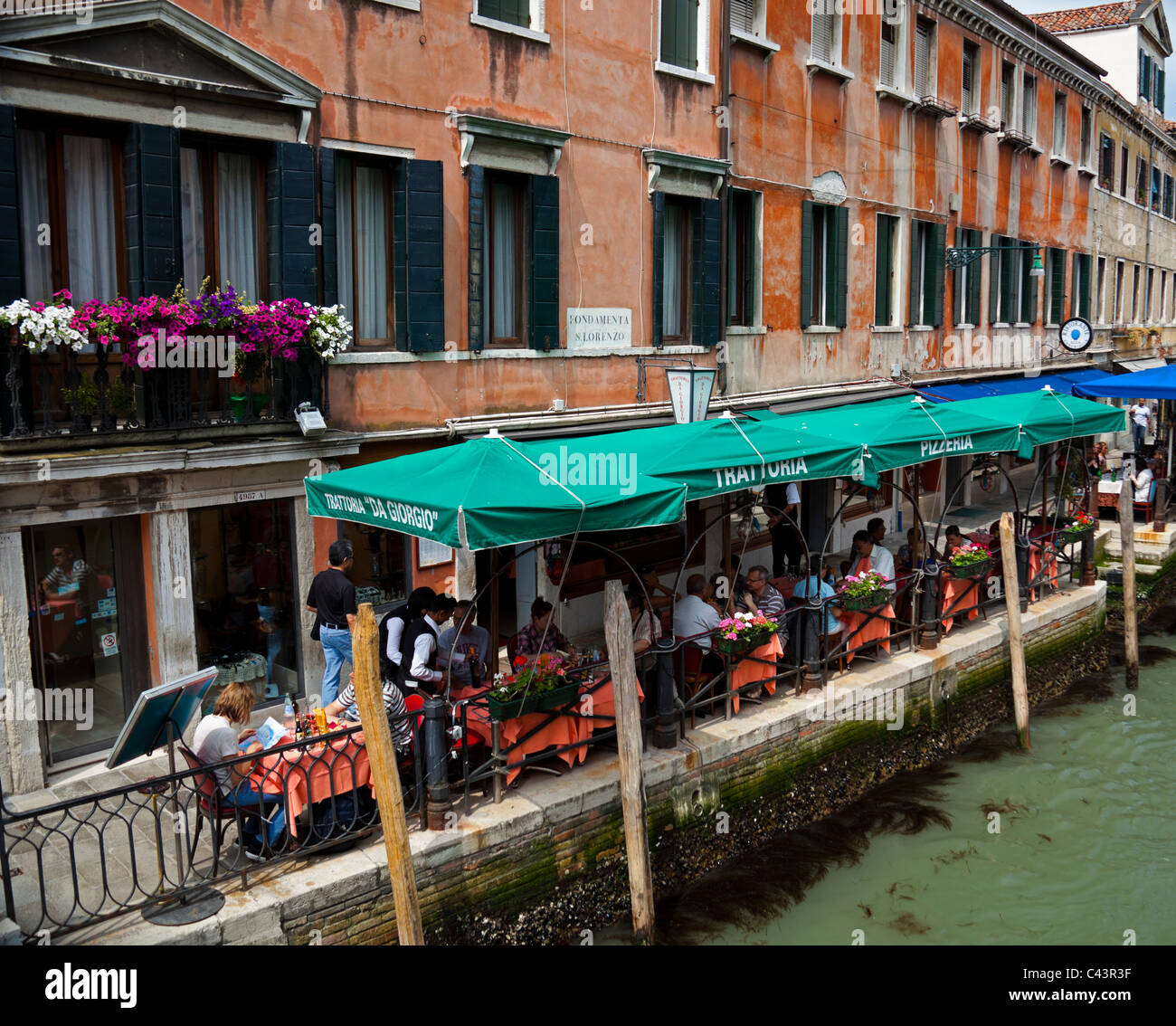 Venice italian restaurant by canal tourists dining Stock Photo