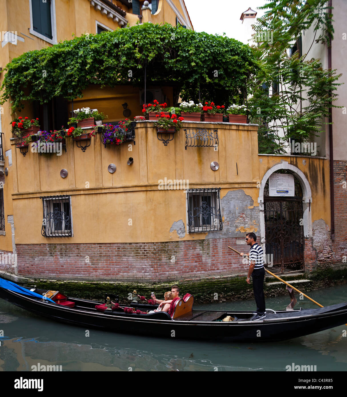 Venice gondola on canal with tourists sightseeing Italy Europe Stock Photo