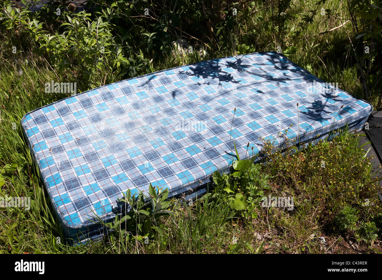 old mattress thrown away discarded by the roadside dumped Stock Photo
