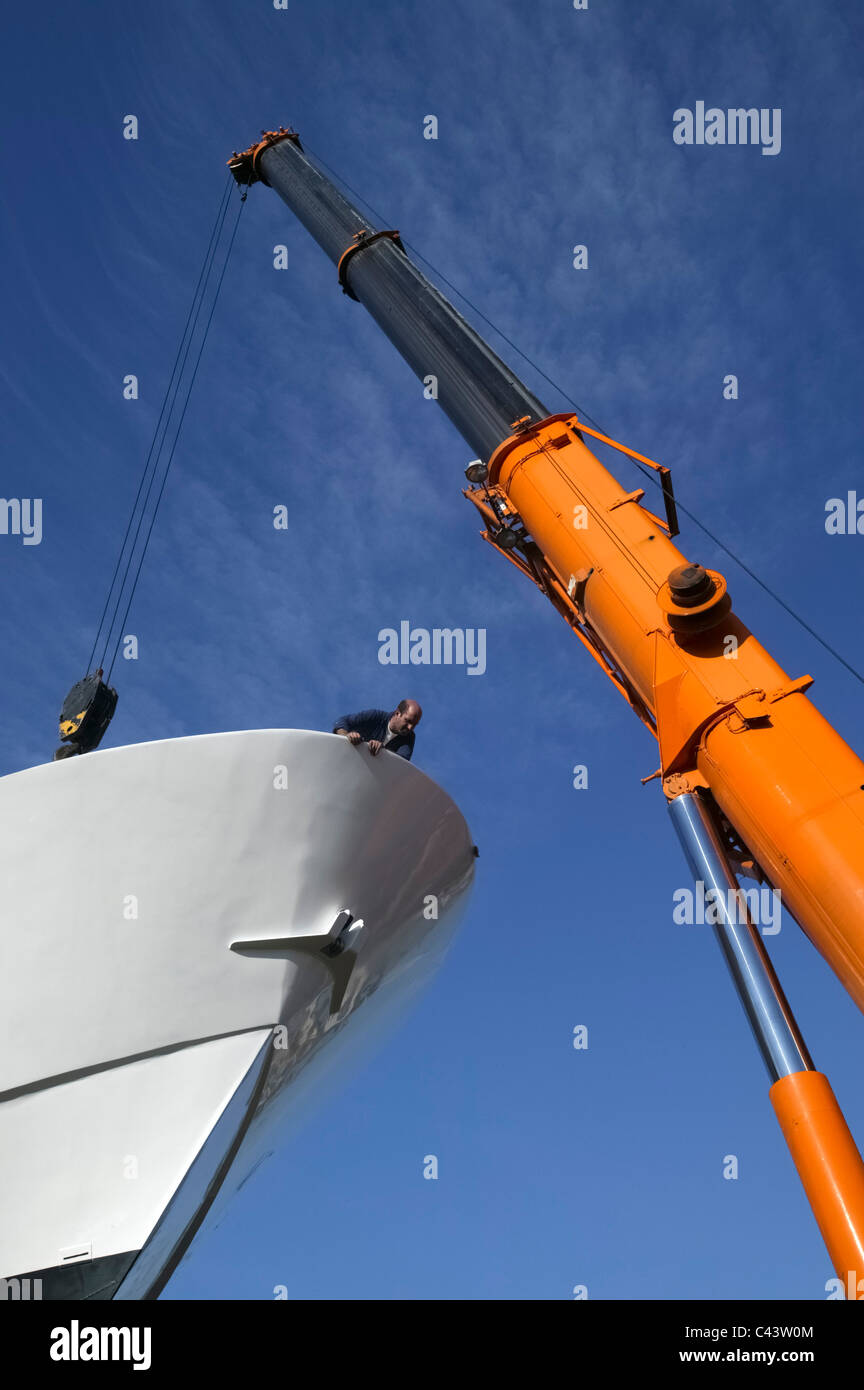 Ship being lifted by crane on a shipyard drydock Stock Photo
