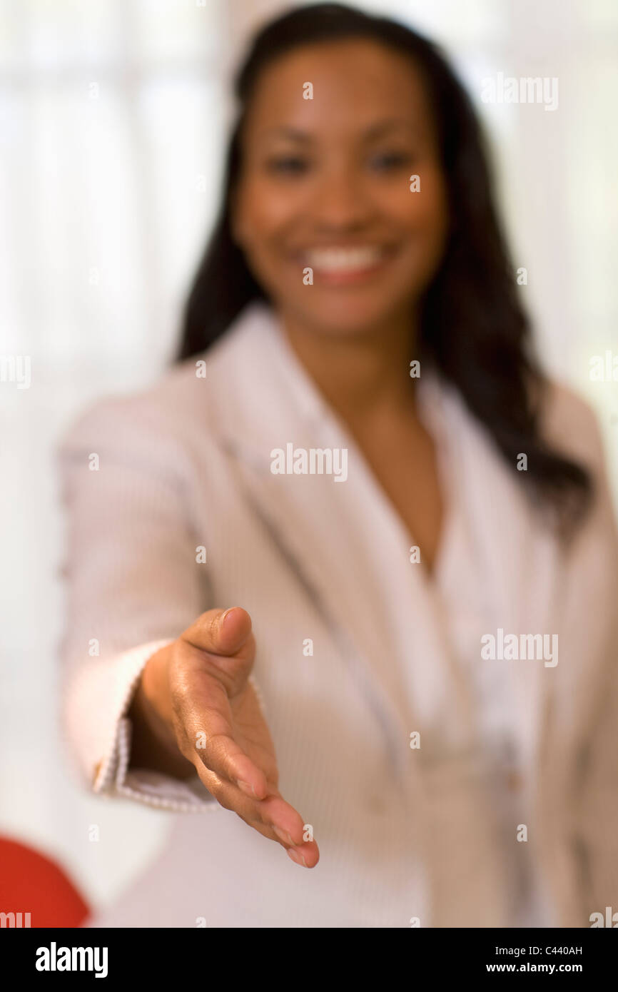 Pretty African American businesswoman extending her hand in greeting Stock Photo