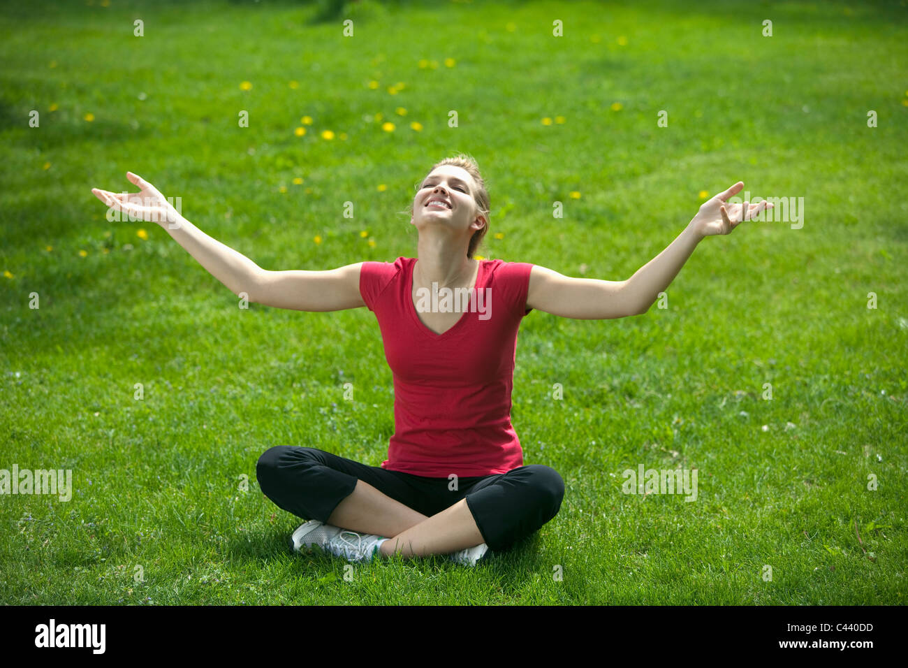 Pretty woman sitting in a park meditating Stock Photo