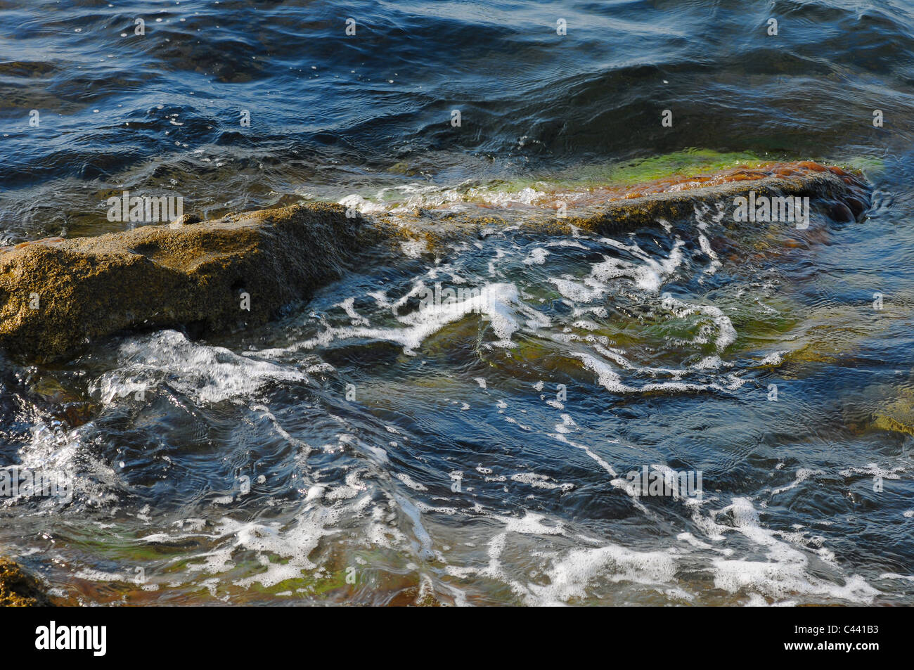 The stone in water is washed by waves Stock Photo - Alamy