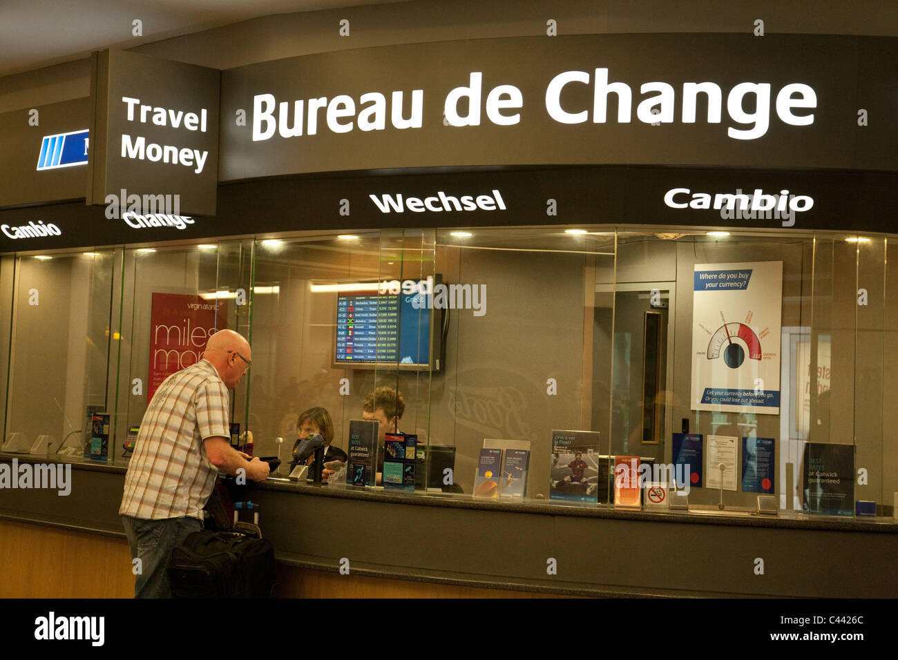A traveller changing money at the Bureau de Change, North terminal, Gatwick Airport UK Stock Photo