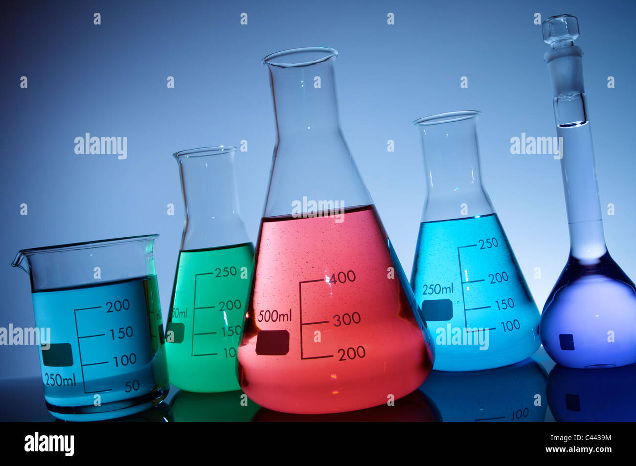 flasks group with color liquid and blue background Stock Photo - Alamy