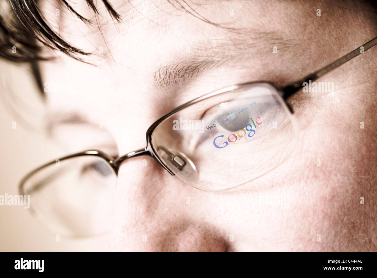 Reflection of search engine Google logo and web page in glasses. Stock Photo
