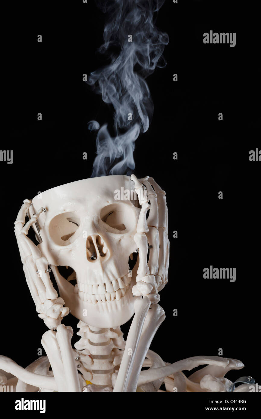 A skeleton with smoke coming out of its skull Stock Photo