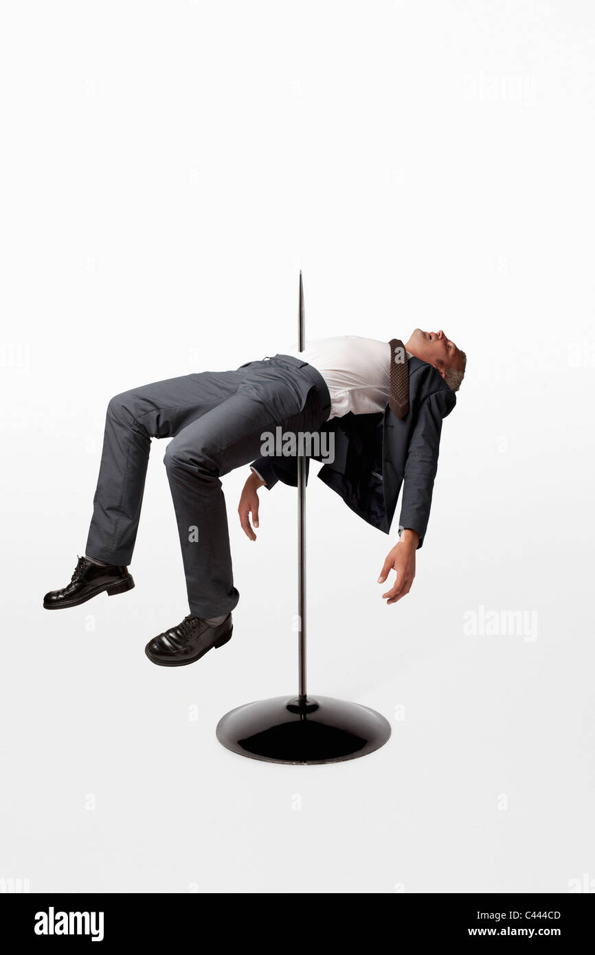 A businessman impaled on a spindle Stock Photo