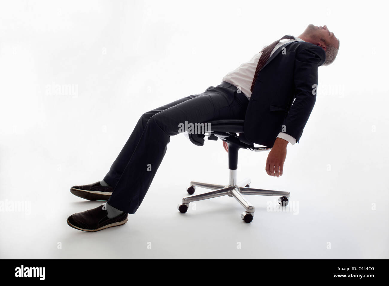 An exhausted businessman sleeping in an office chair Stock Photo