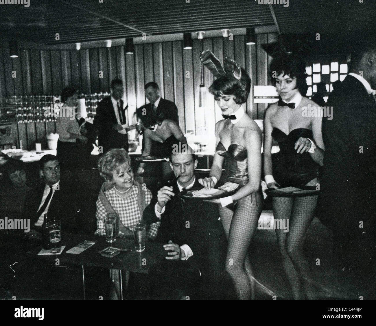 HUGH HEFNER founder of Playboy magazine with Bunnies in one of his Playboy Clubs about 1965 Stock Photo