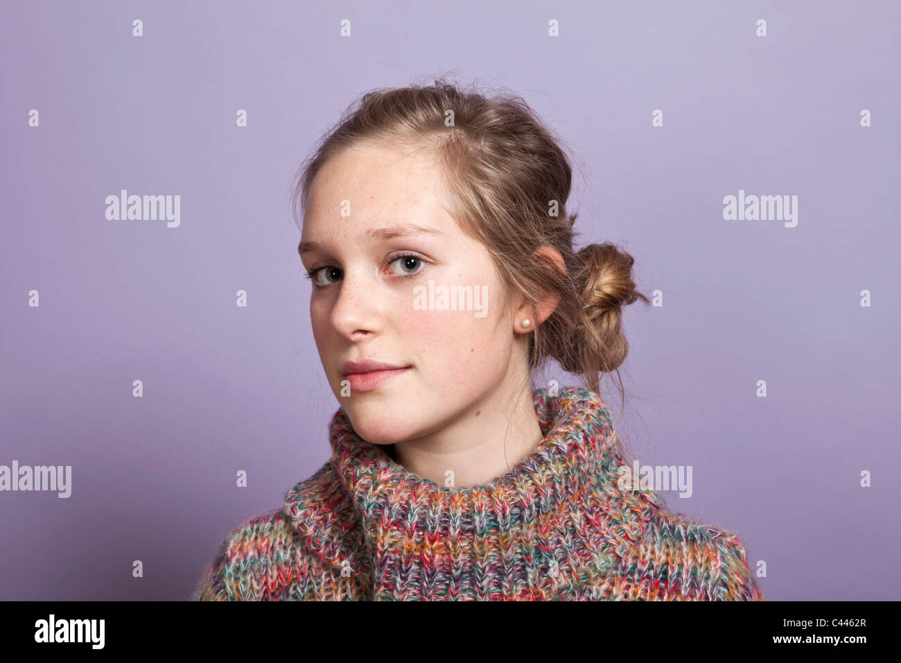 A teenage girl give a sideways glance to the camera, portrait, studio shot Stock Photo
