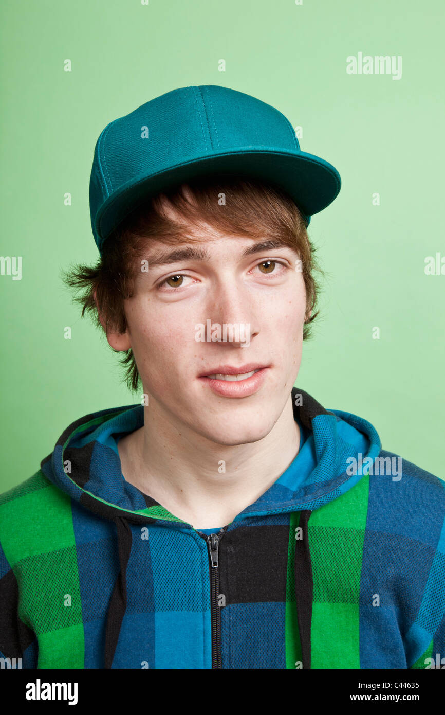 A teenage boy wearing a hoodie and baseball cap, portrait, studio shot Stock Photo