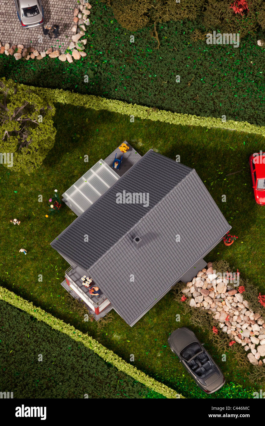 A diorama of miniature cars, people and a house, directly above Stock Photo
