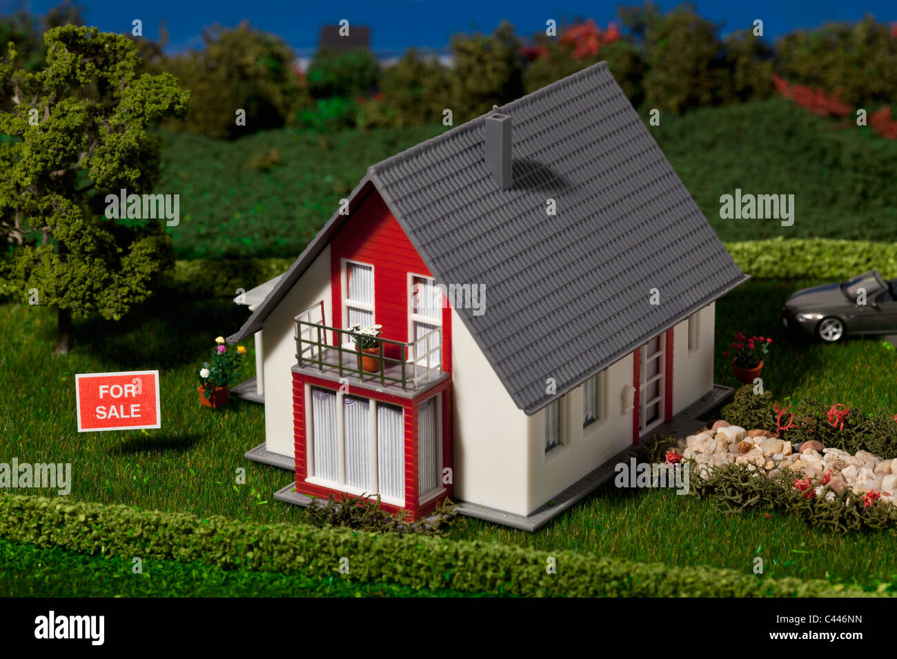 A diorama of a miniature house with a FOR SALE sign Stock Photo