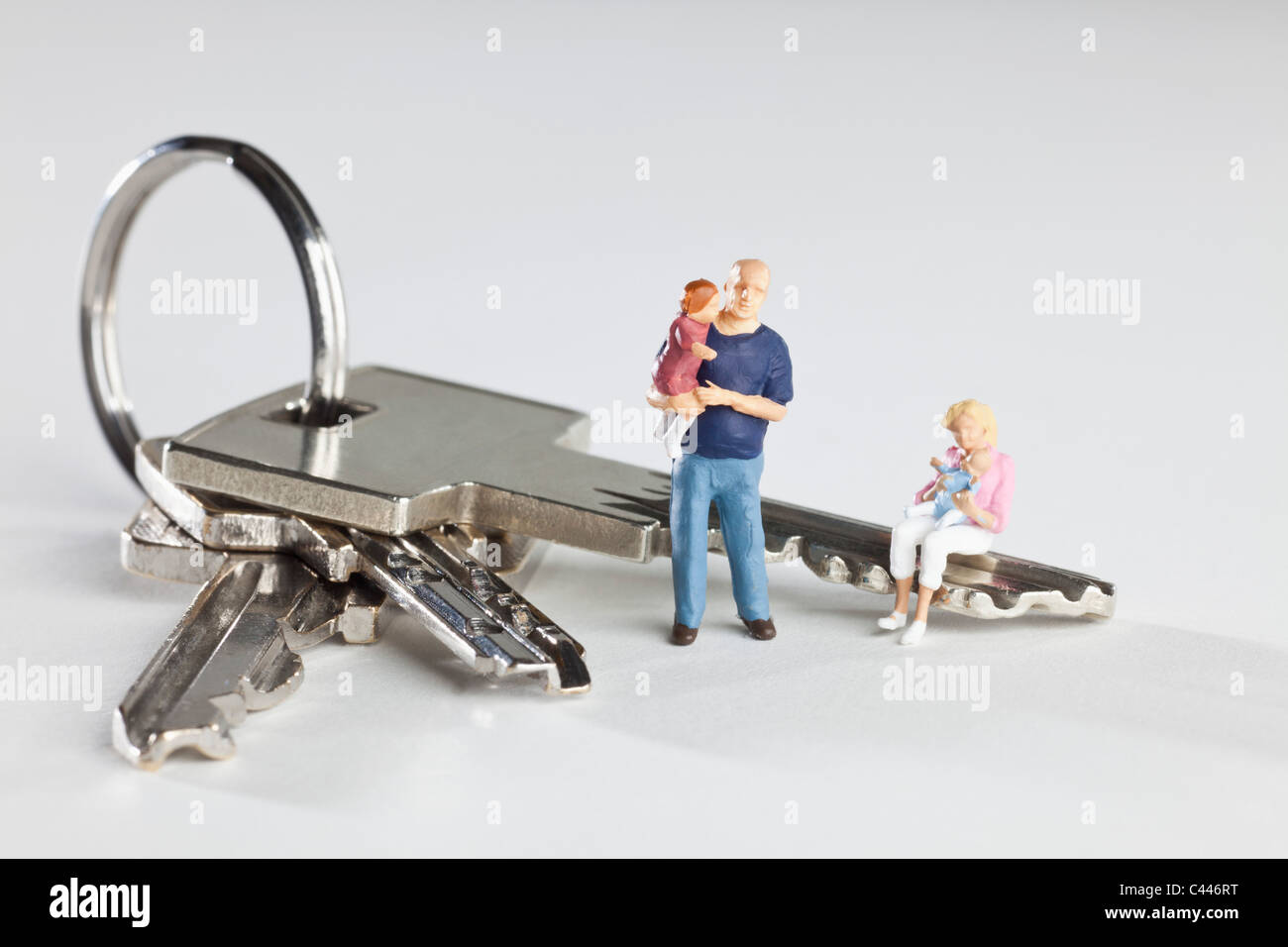 A young family of miniature figurines and house keys on a key ring Stock Photo