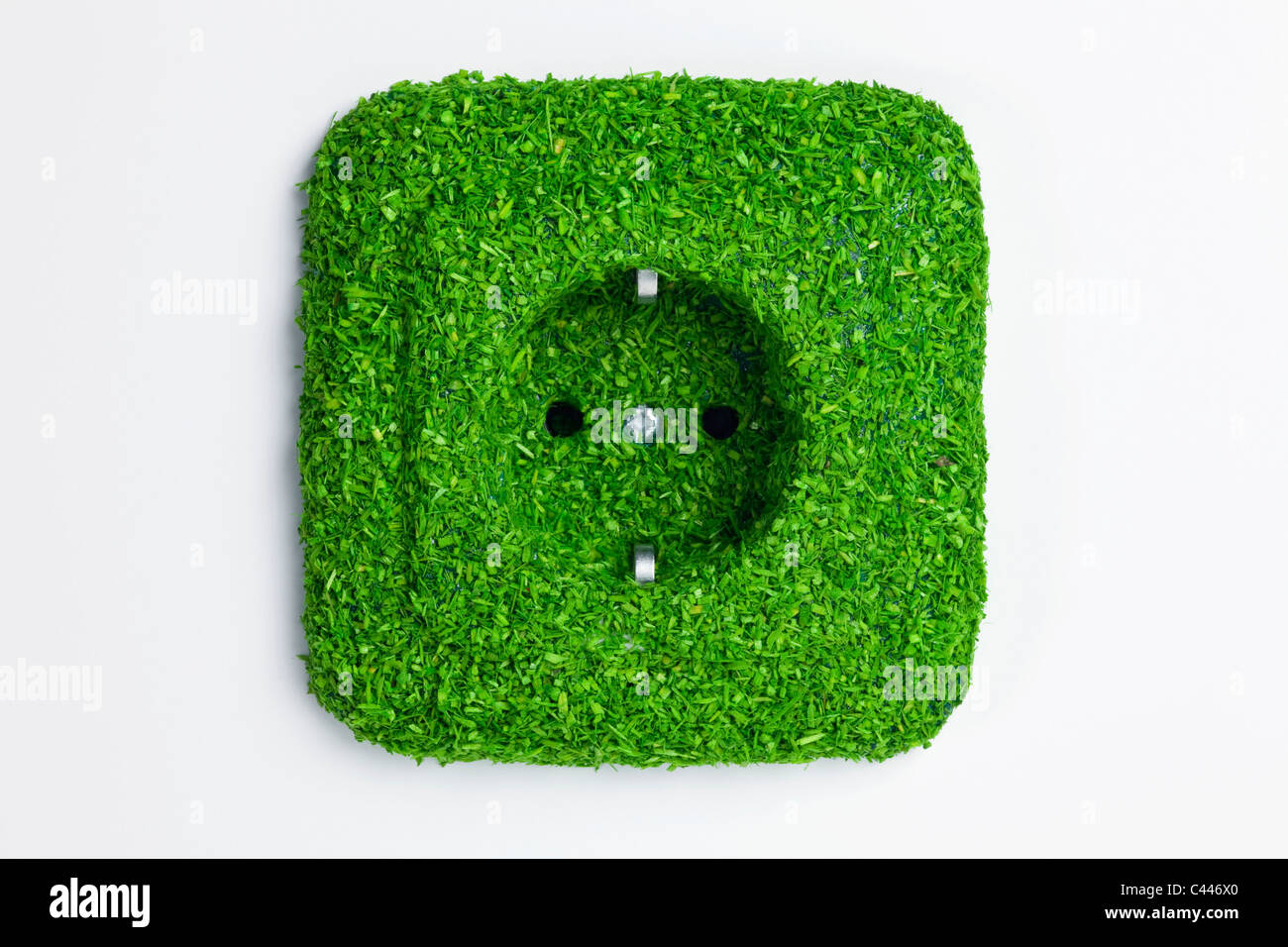 Energy saving electrical wall outlet covered in green grass Stock Photo
