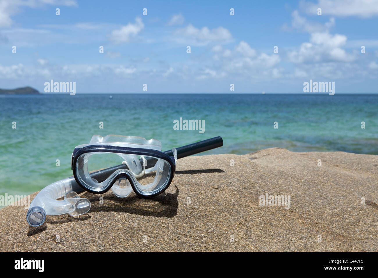A diving mask and snorkel on a rock near the sea Stock Photo