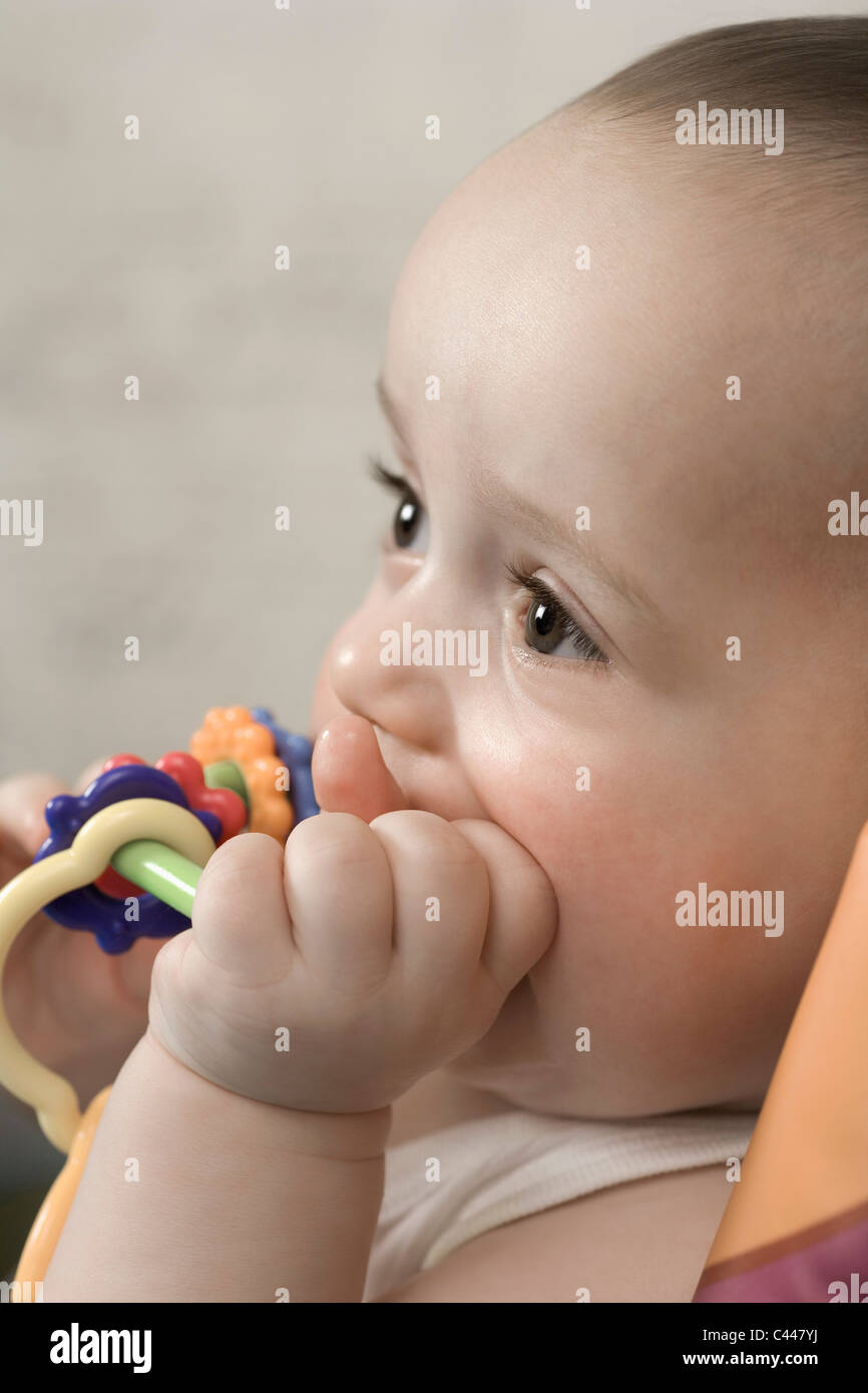 A baby gnawing on a teething ring Stock Photo