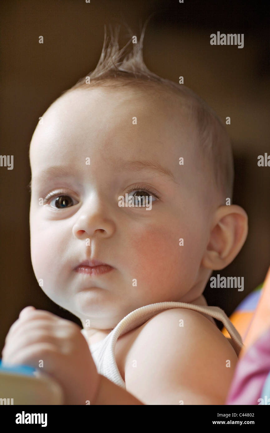 A baby looking seriously into the camera Stock Photo