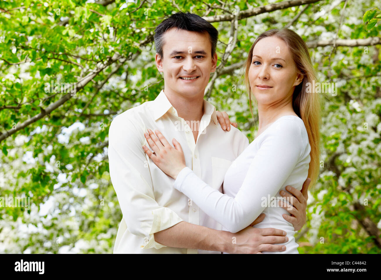 Portrait of young couple looking at camera in park Stock Photo - Alamy