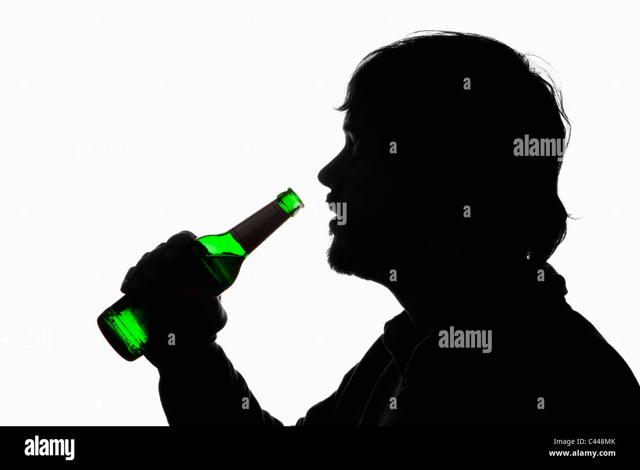 A silhouetted man about to drink from a beer bottle Stock Photo Alamy