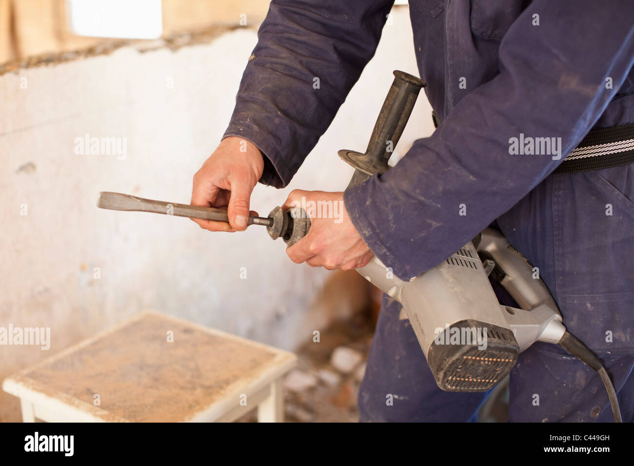 A manual worker attaching a drill bit to a drill Stock Photo Alamy