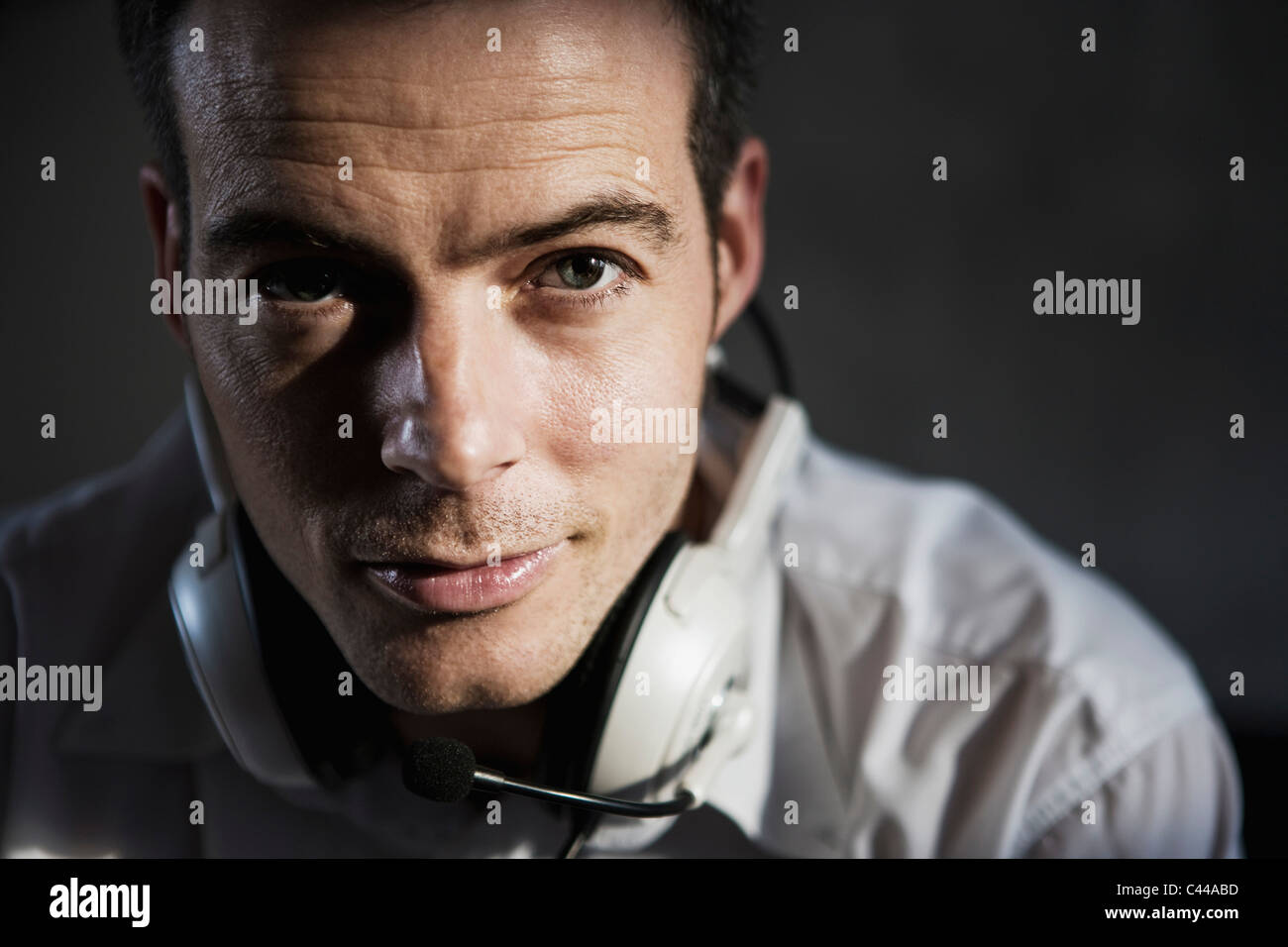 A man wearing a headset around his neck hires stock photography and